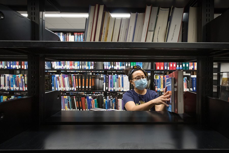 A staff member organizes books in the McGoogan Health Sciences Library..