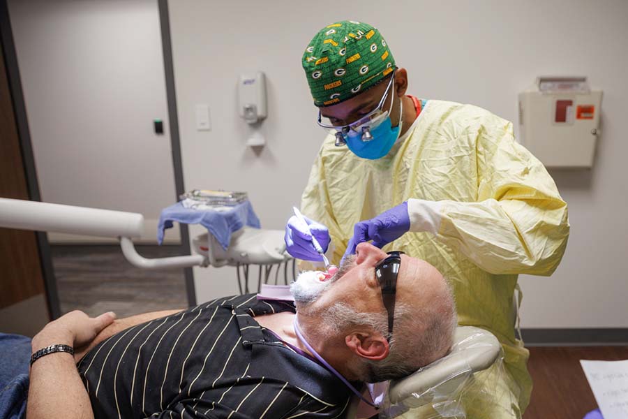 A dentistry faculty member examines the mouth of a veteran during a special clinic.