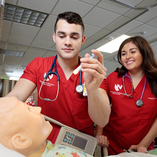 Nursing students work with a simulator