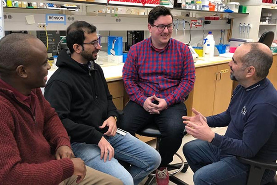 Howard Gendelman, MD, far right, talks in his lab with, from left, Benson Edagwa, PhD; Aditya Bade, PhD; and Brady Sillman, PhD.