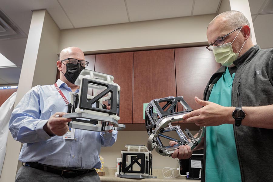 Brian Maass, left, of the McGoogan Health Sciences Library’s makerspace, displays the completed replica to Dennis Rieke of the UNMC Department of Neurosurgery.