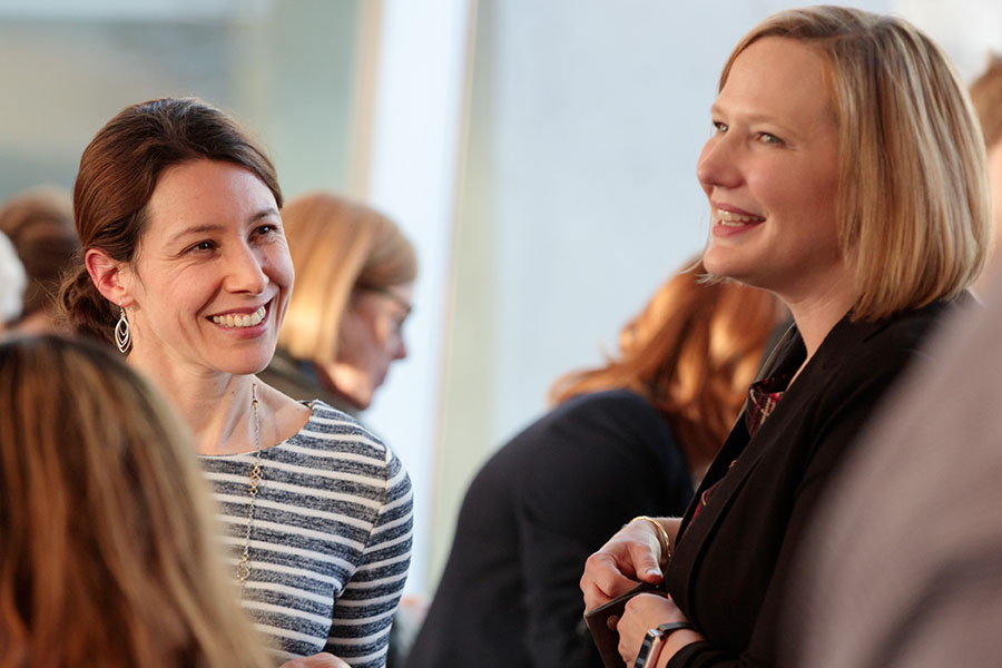 Faculty members talking at event