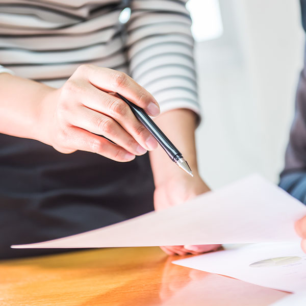 Two people talking over paperwork