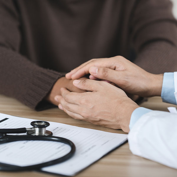 Behavioral health care provider holding patient hand