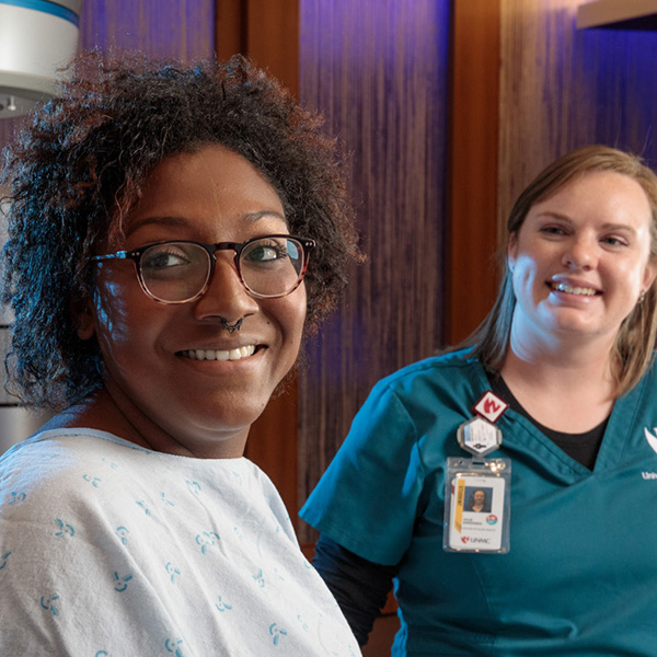 Doctor, nurse and patient talking in an exam room