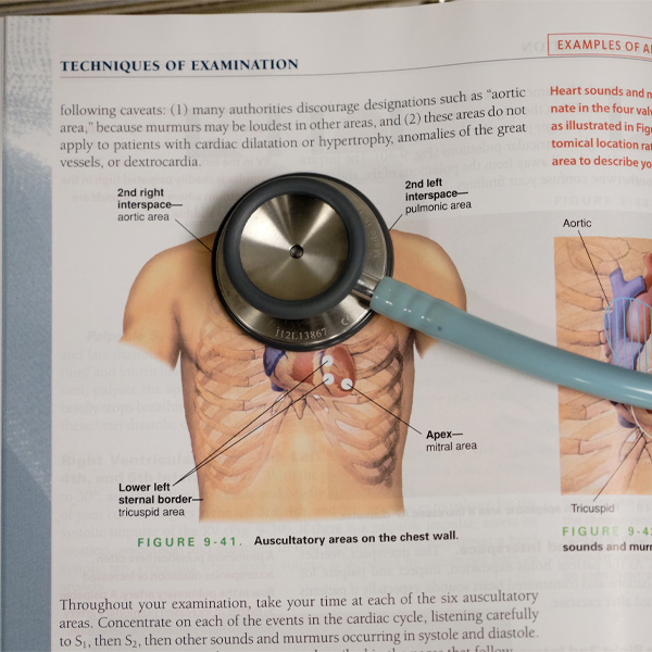 Open medical book with stethoscope laying on top