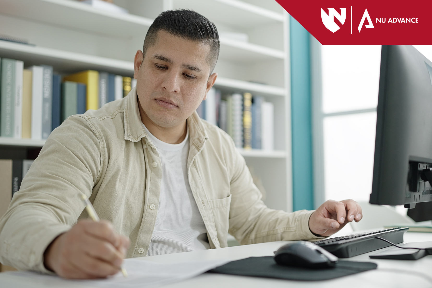 Student sits at computer taking notes