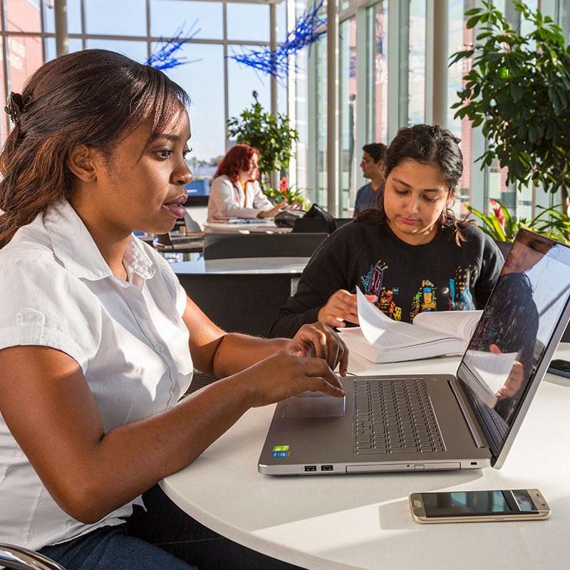 Student sitting at table typing on computer