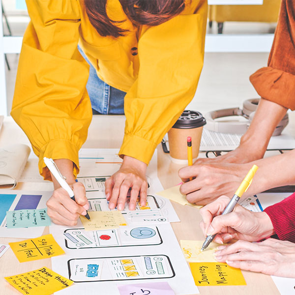 people brainstorming with sticky notes and markers on table