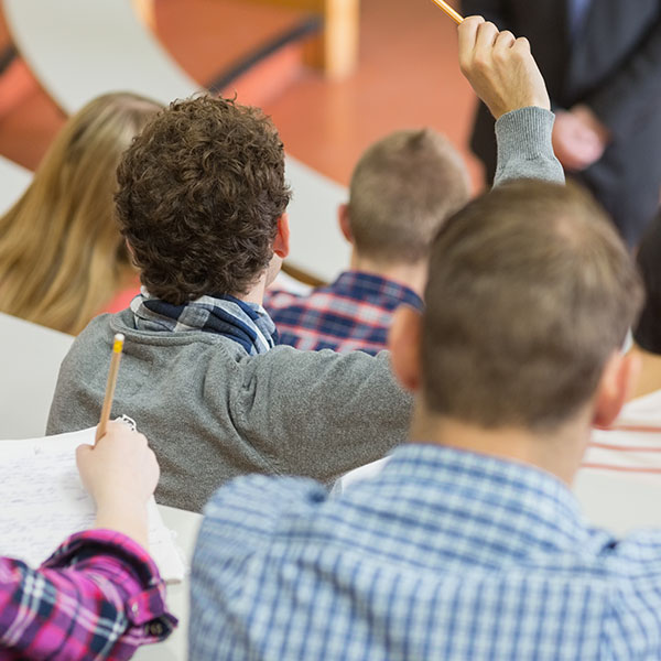 students sitting in class with teacher at front