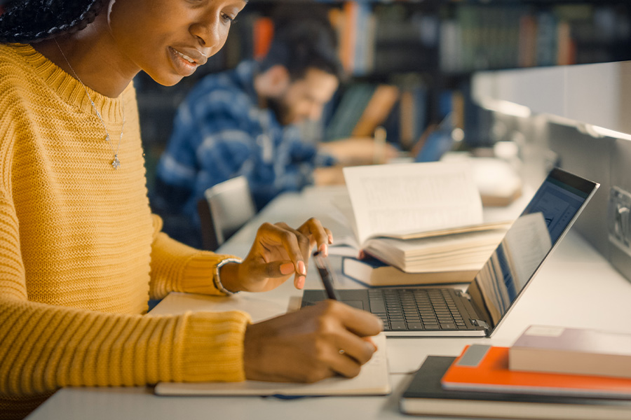 woman writing in library