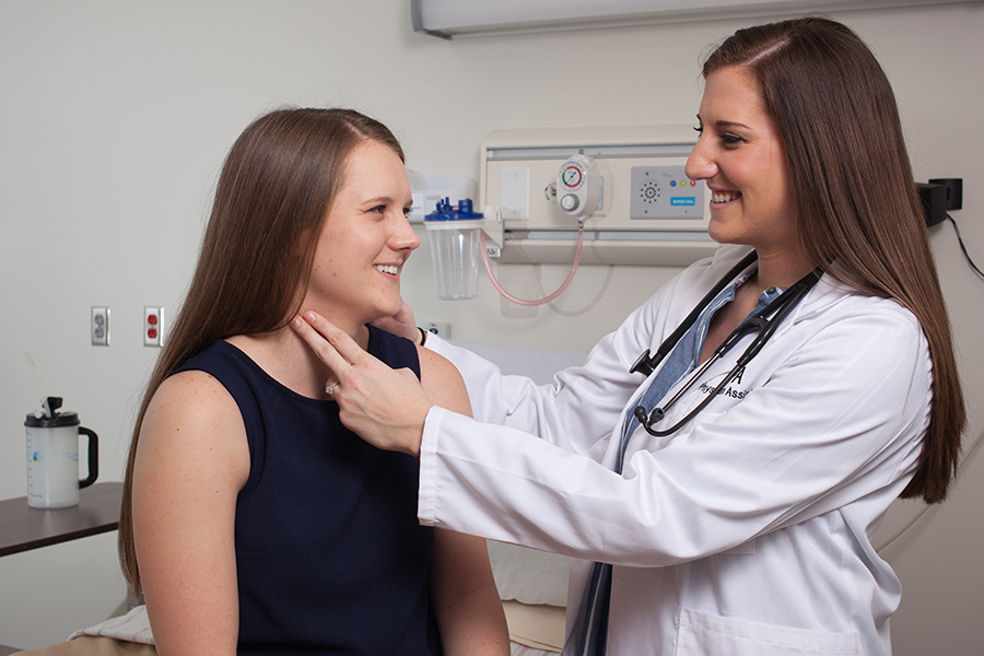 PA listening with stethoscope to patient