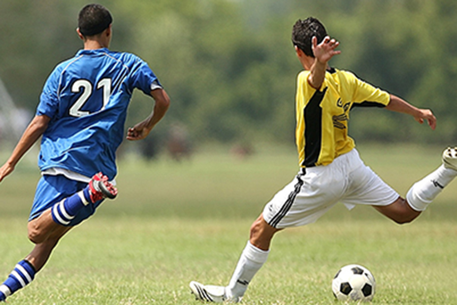 Two men playing soccer on a field