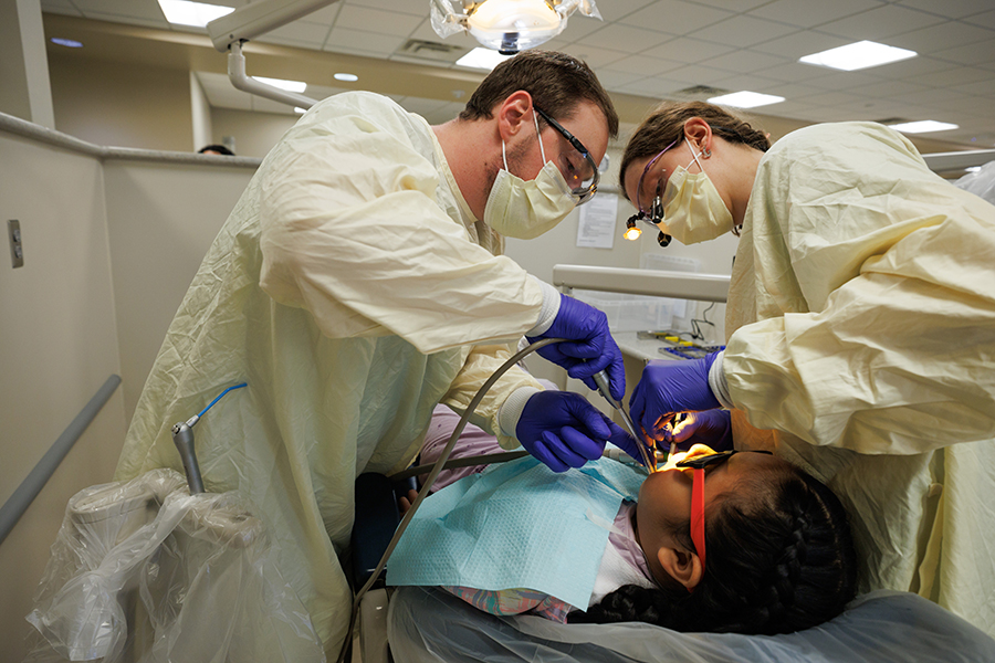 Dental students working on a child patient.