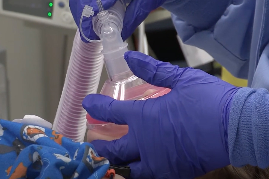 Latex gloved hands holding syringes.