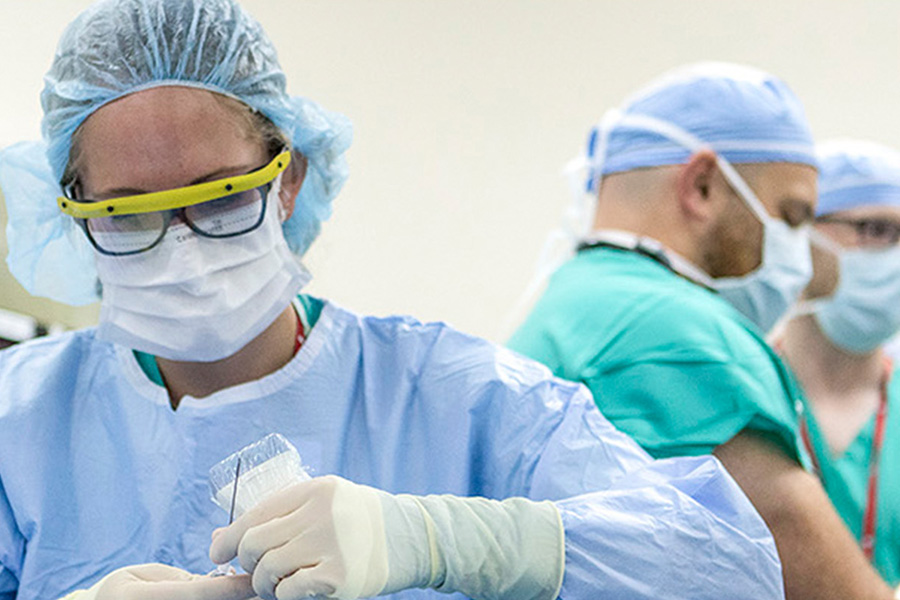 Close up of a female anesthesiologist in an OR wearing scrubs.