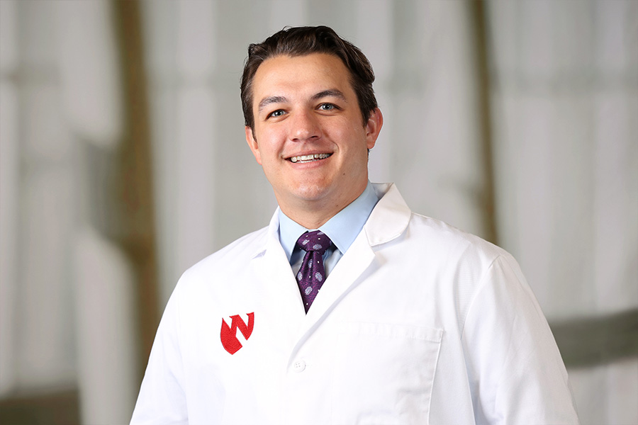 Colton Roessner, MD, headshot with white lab coat