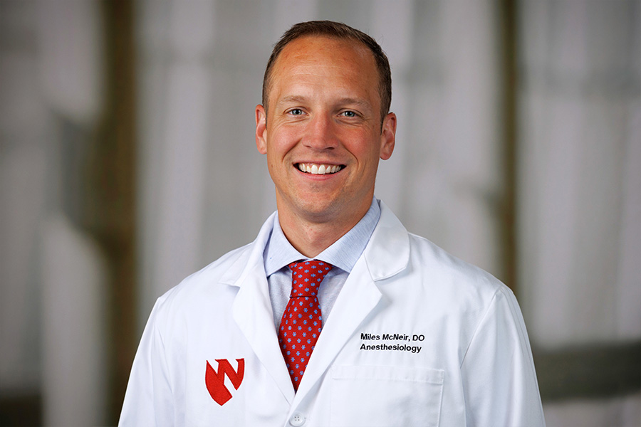 Miles McNeir, DO, headshot with white lab coat