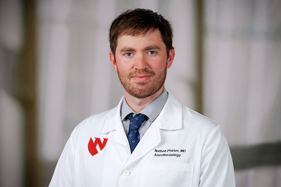 Nathan Pfister, MD, headshot with white lab coat
