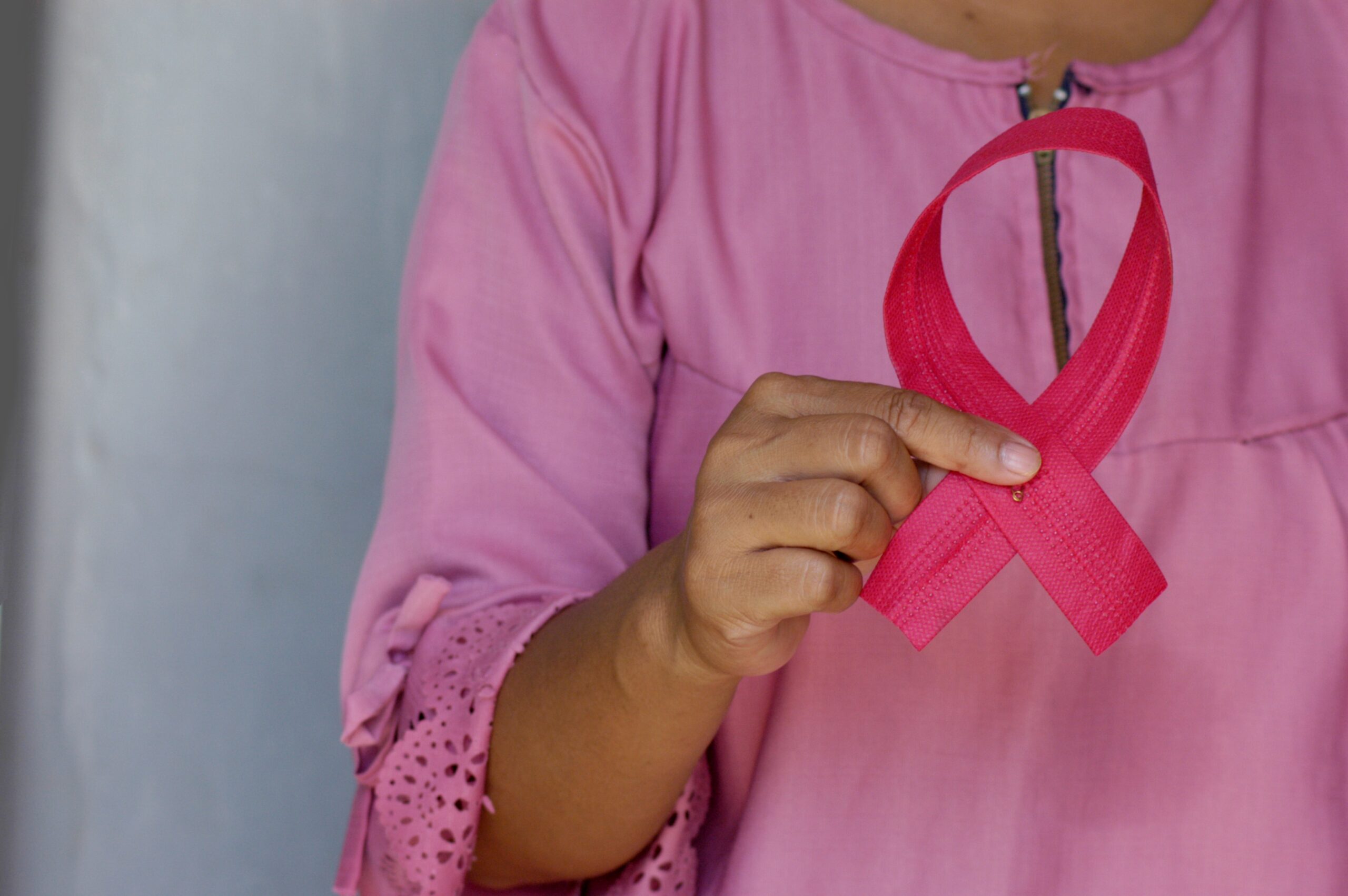 woman holding pink ribbon