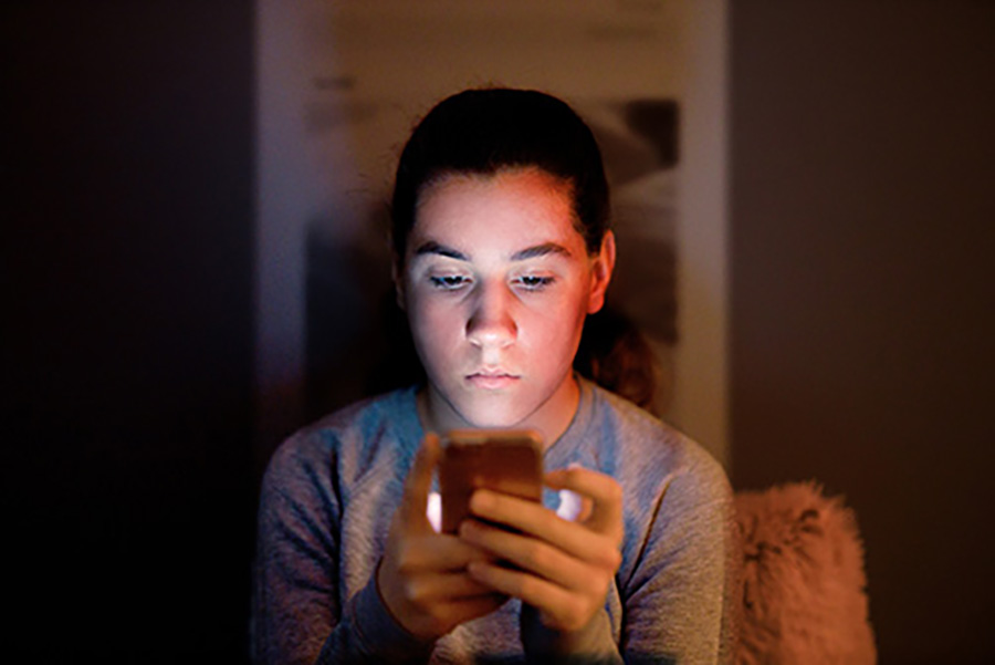 Teenager uses a smartphone. 