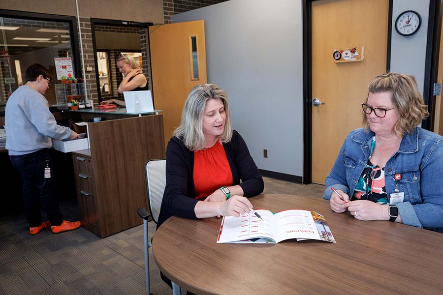 A printing services managers reviews a product with a client.