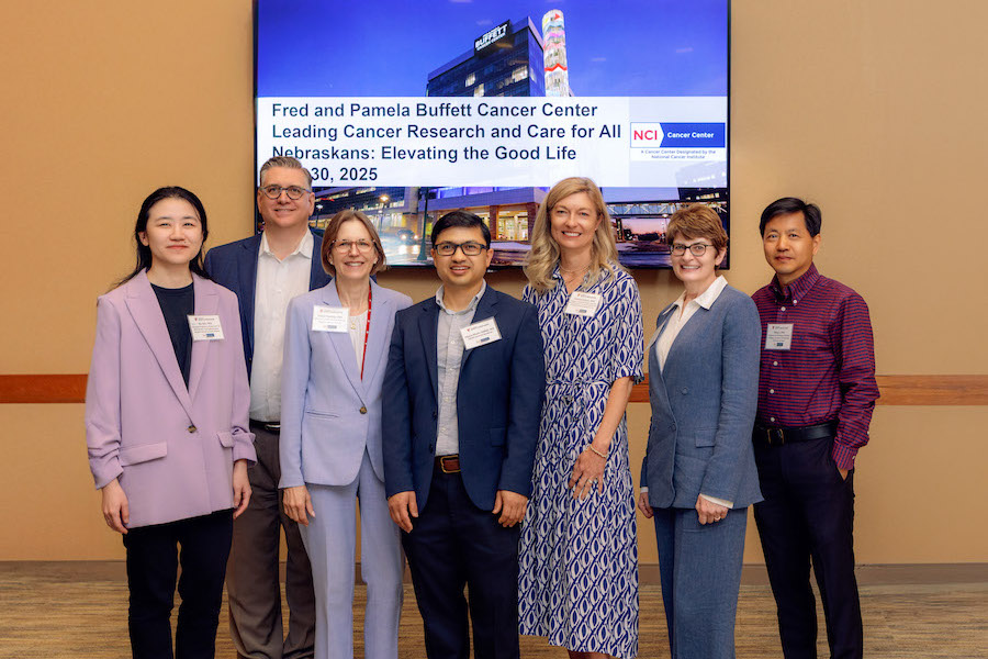 Symposium attendees, including the Cancer Center director, program leaders, and guest speakers.