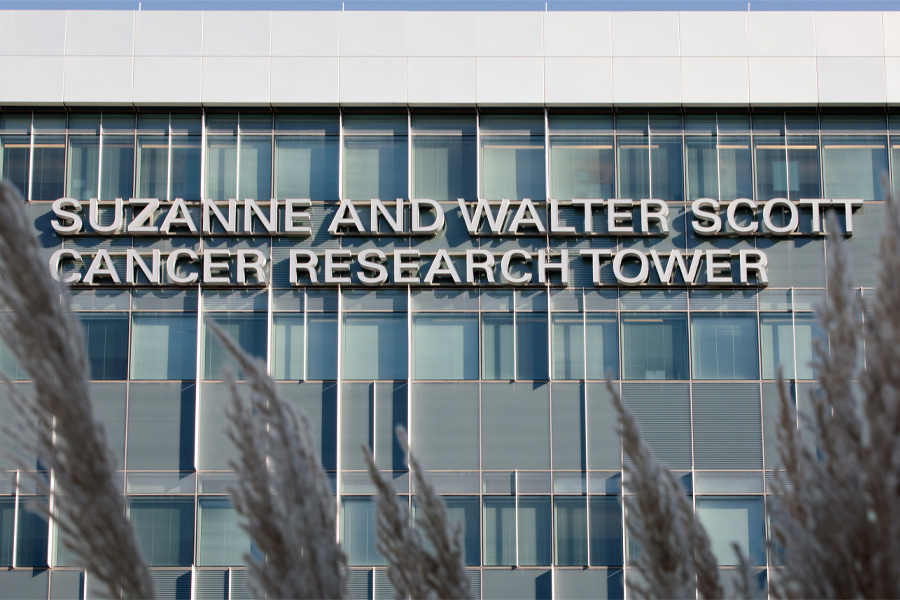 Exterior of a building with a sign reading Suzanne and Walter Scott Cancer Research Tower