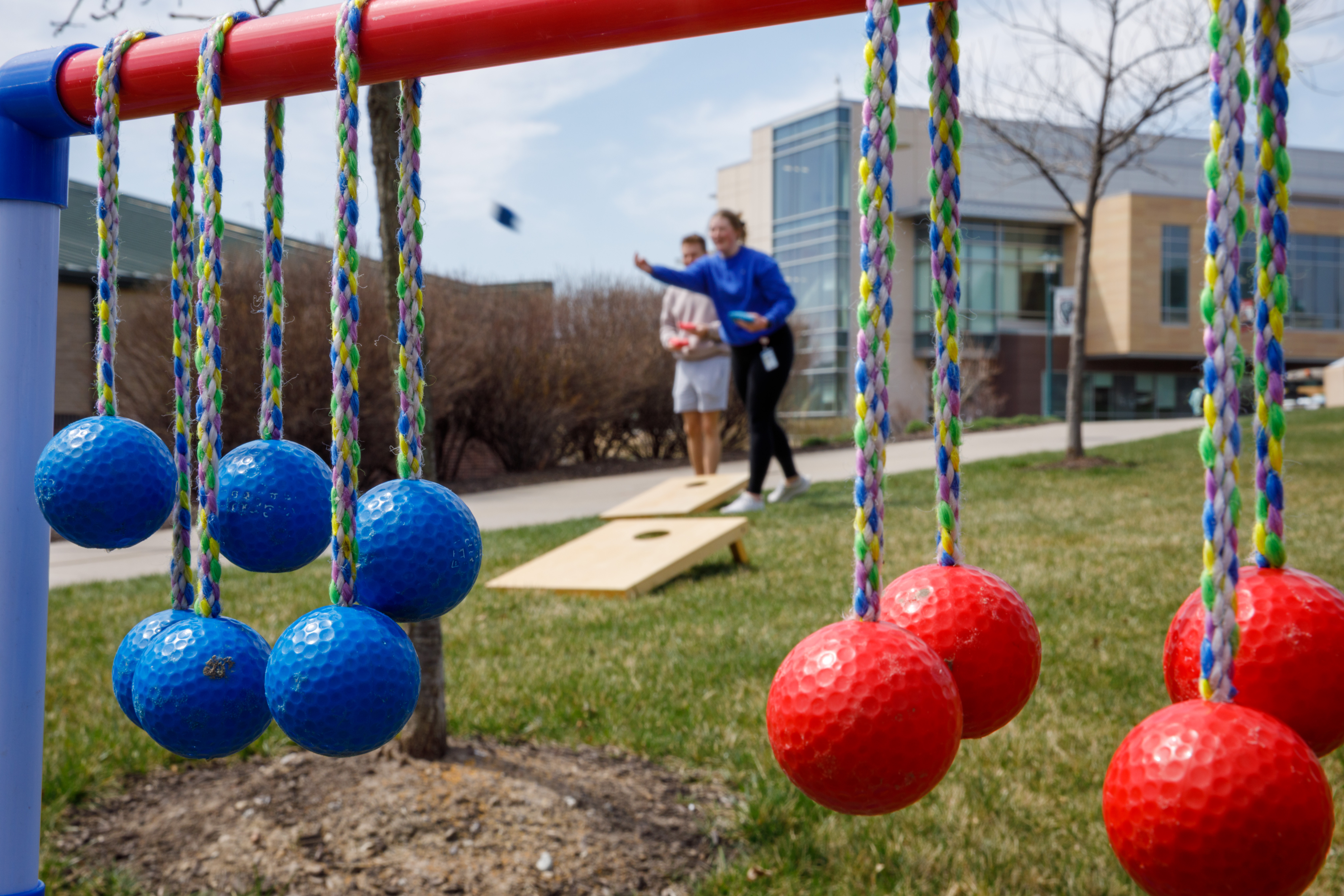 A male and female student play ladder golf outside the Center for Healthy Living