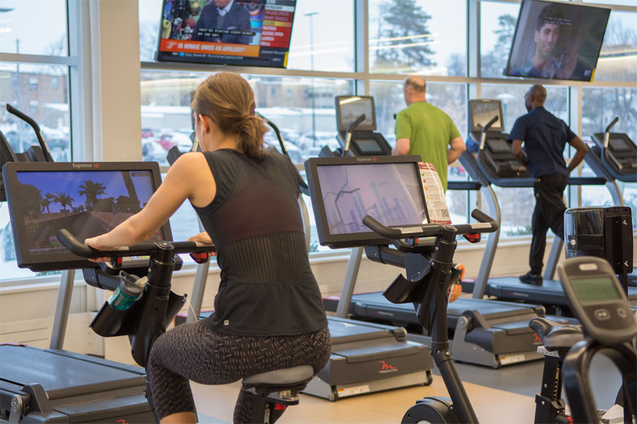 Fitness members use cardio equipment