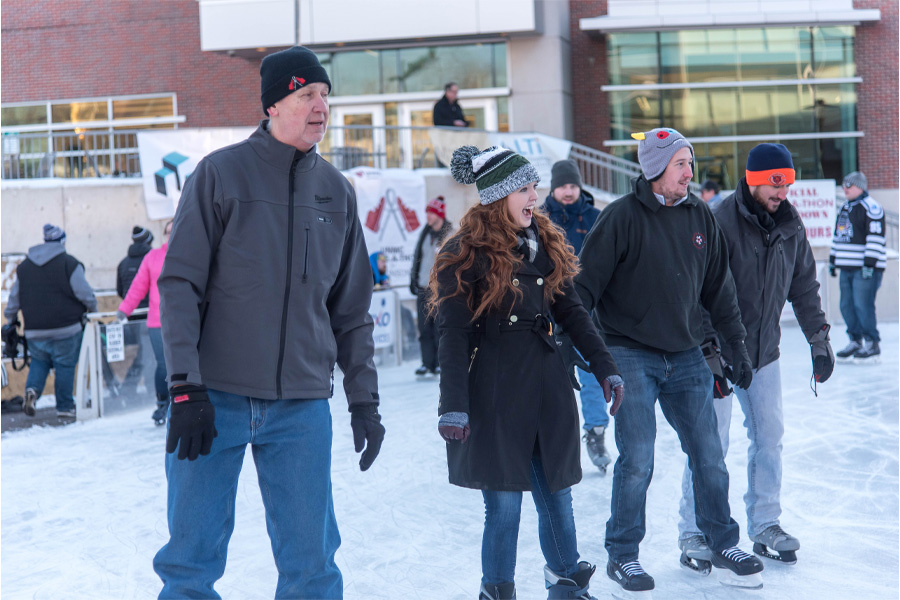A group of people skate on the UNMC ice rink