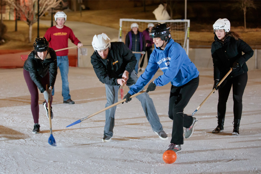Students playing broomball on an ice rink