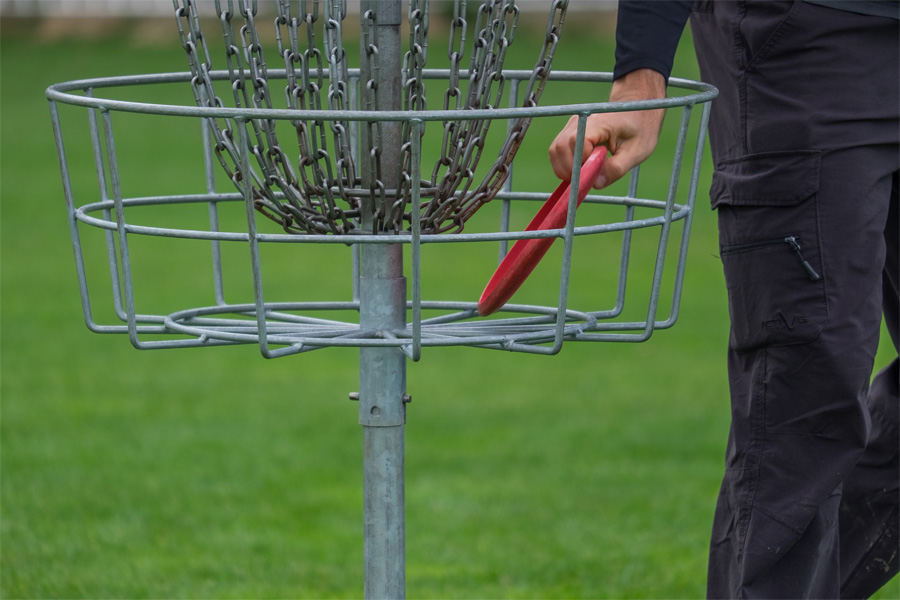 A frisbee in a basket for disc golf