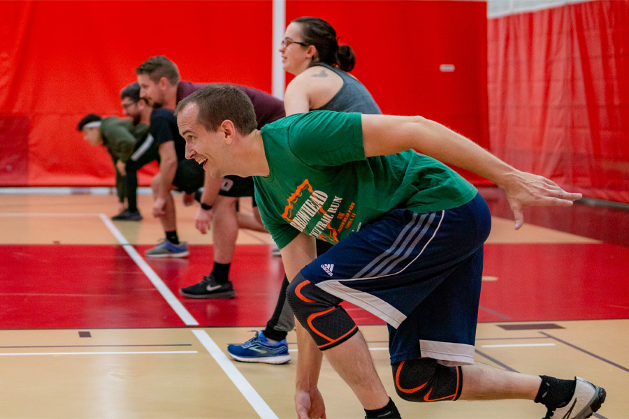 Students line up in a gymnasium to begin a game of dodgeball