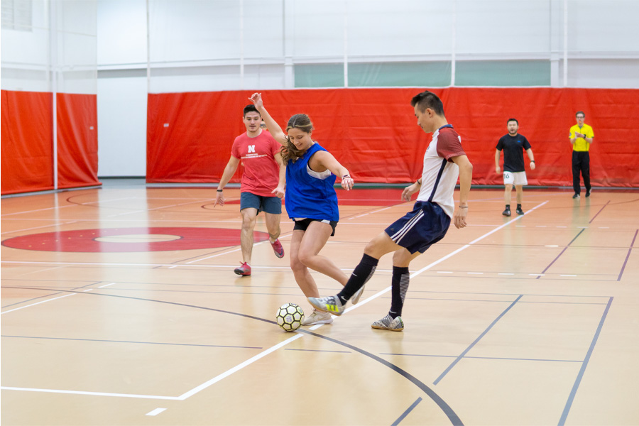Students play indoor soccer in a gymnasium