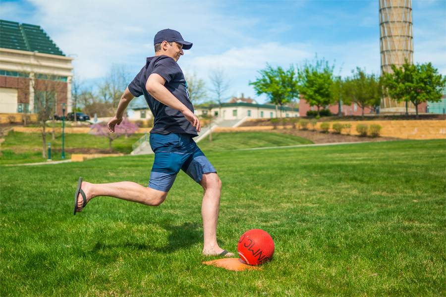 A man aims a kick at a rubber ball