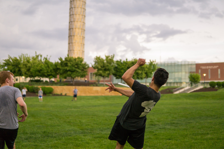 A man watches the trajectory of a thrown frisbee