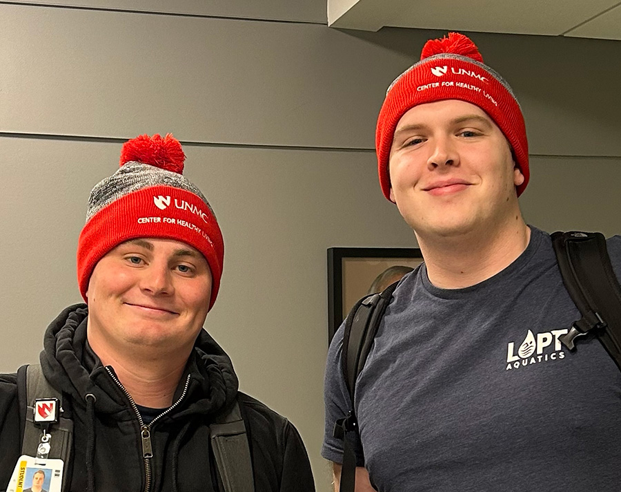two students wearing UNMC Center for Healthy Living beanies
