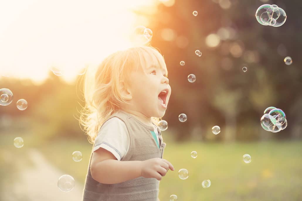 toddler chasing bubbles