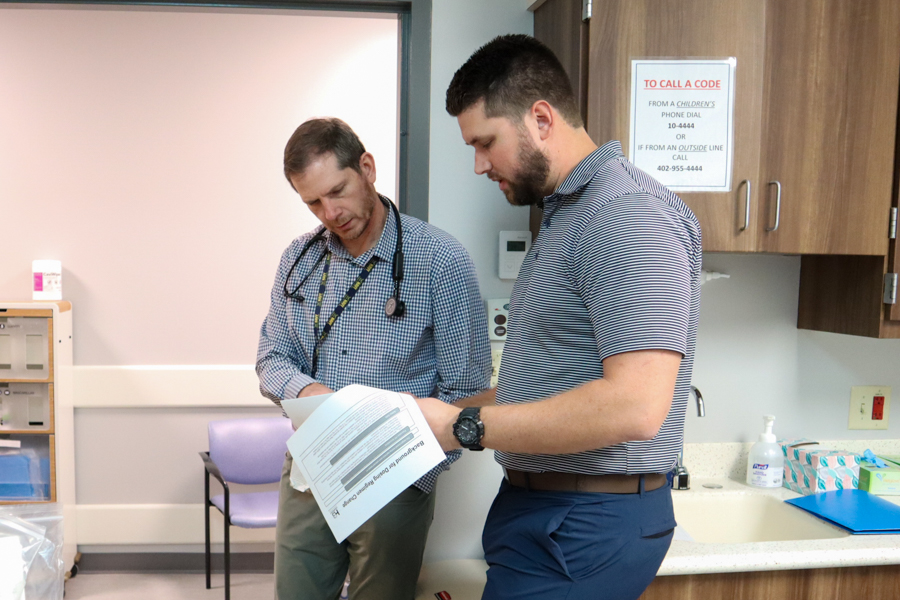 doctor and study coordinator talking outside a doorway in a clinical office