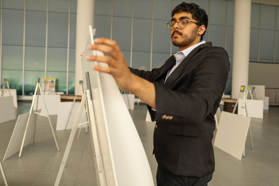 man puts up scientific poster