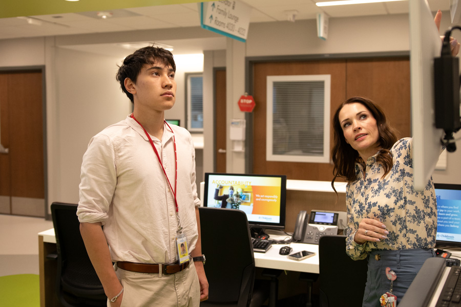 female physician shows medical equipment to mail trainee