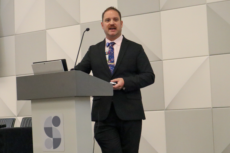 Man leaning on podium presenting at scientific conference