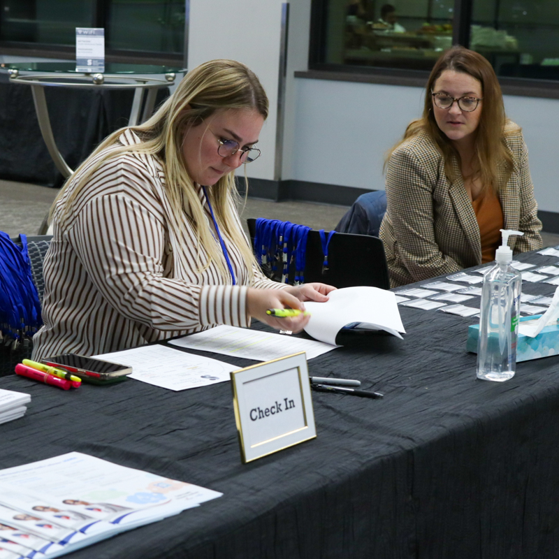 two women sitting at registration table