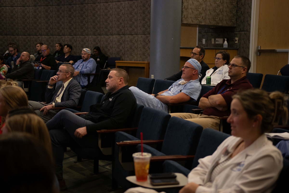 people sitting in audience listening to speaker off camera to the left