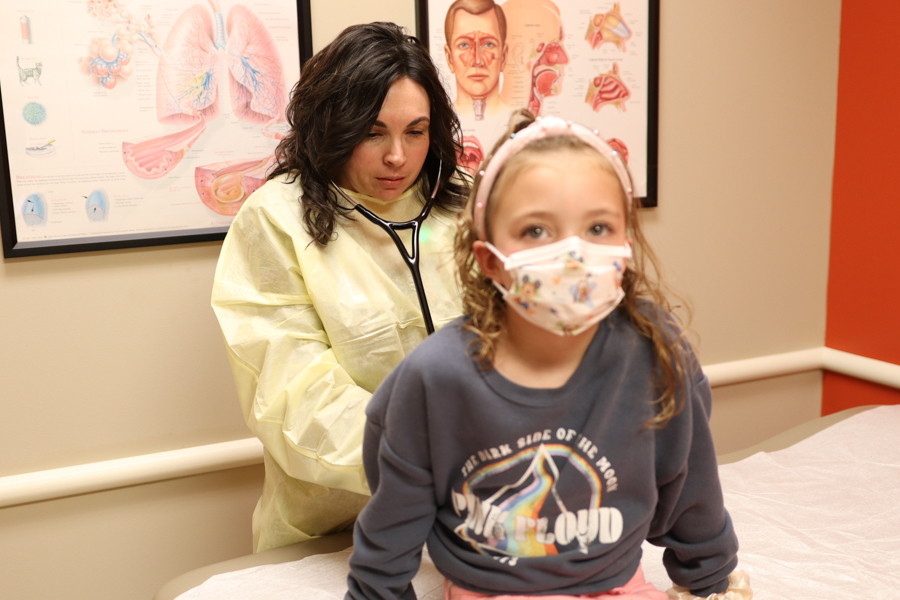 doctor listening to the back of a child