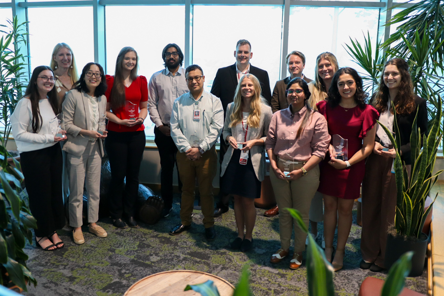 Group of young adults posing holding research prizes
