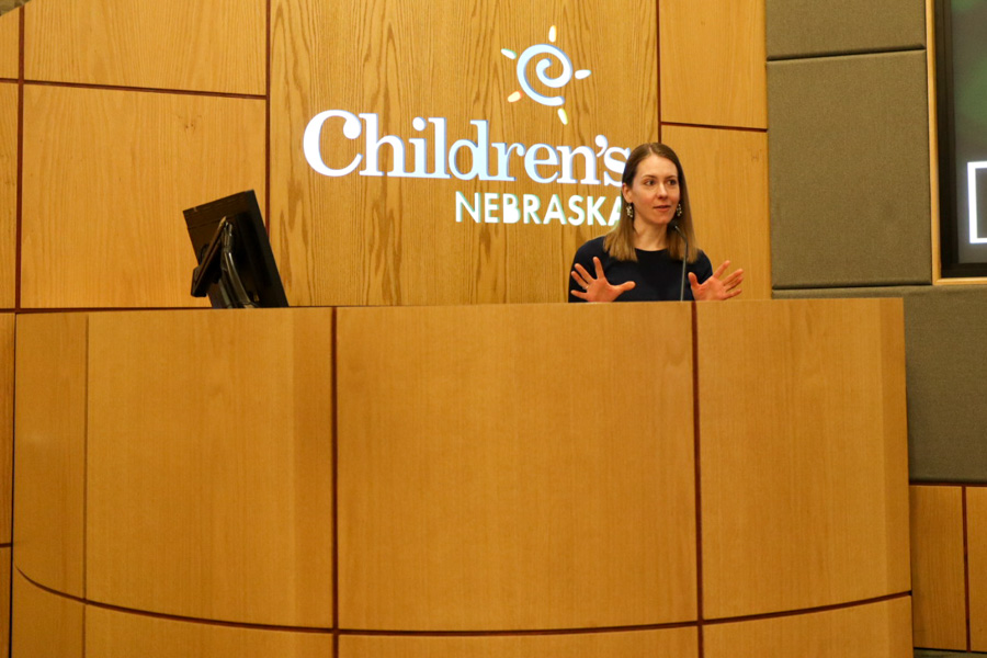 woman talking at podium with seated woman listening to her