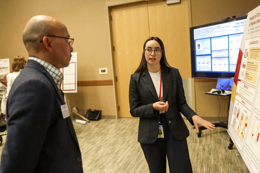 woman discussing her scientific poster with another researcher