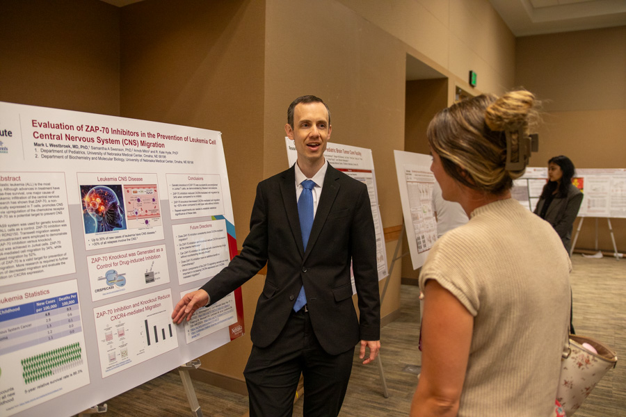 man presents scientific poster to woman